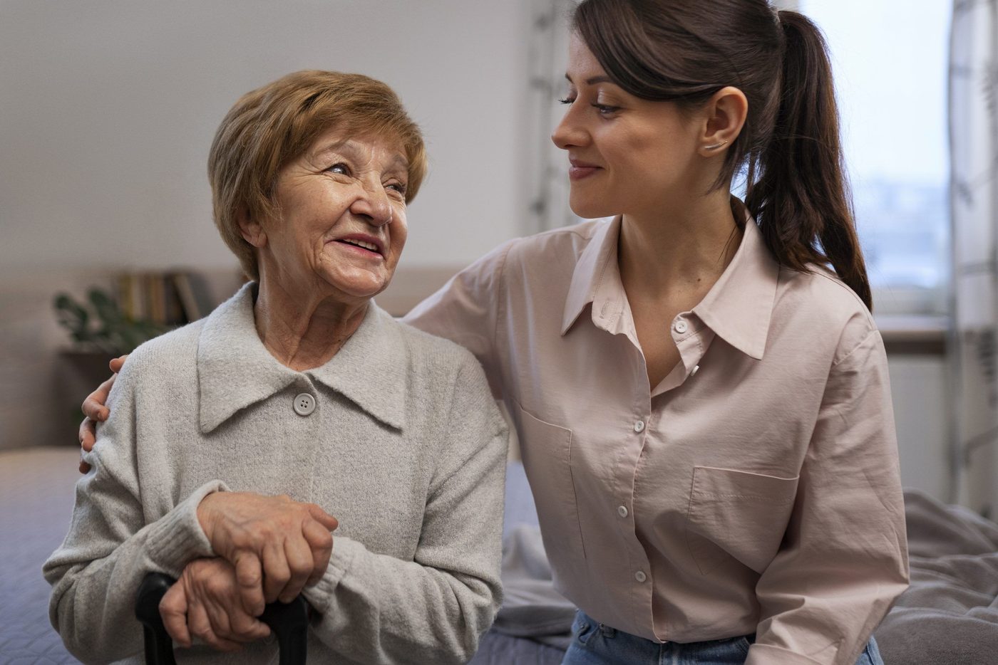 A home carer walking arm in arm with an elderly woman