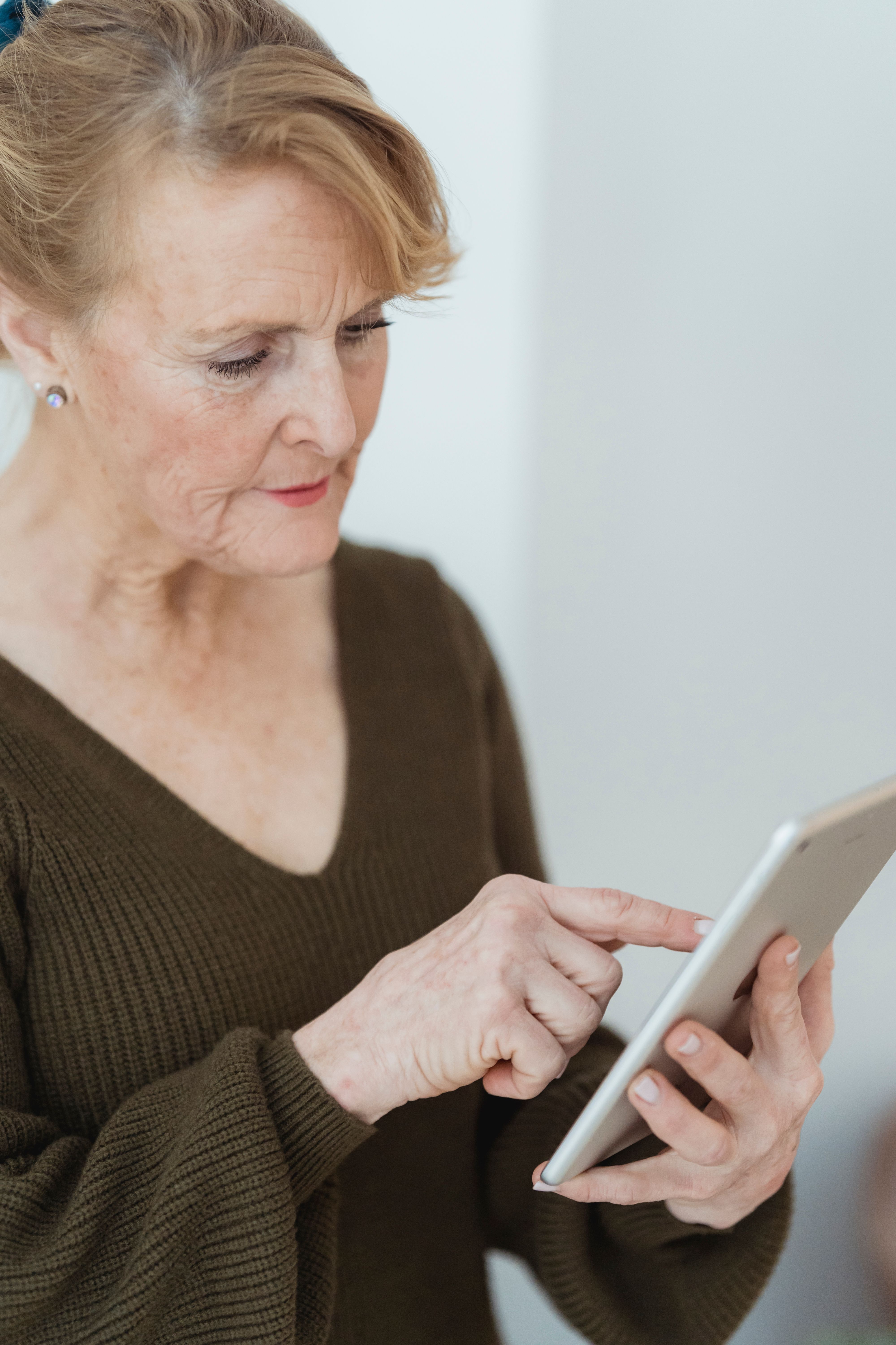 Older woman at home using a tablet, representing AI-supported health monitoring